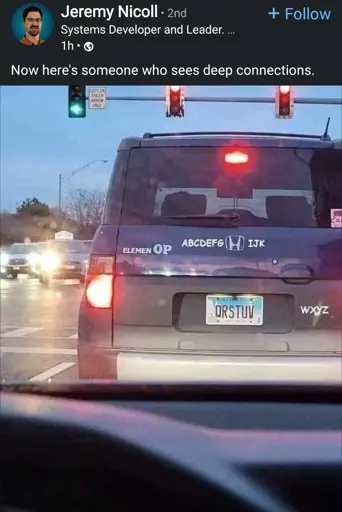 A rear view of a dark blue SUV with a license plate that reads "QRSTUV". On the back of the car, decals spell out parts of the alphabet: "ELEMEN OP" on the left, "ABCDEFGH IJK" above the license plate, and "WXYZ" on the right. The car is stopped at a traffic light, which shows a green signal for straight ahead but a red arrow for a left turn. The image is a screenshot from a LinkedIn post by Jeremy Nicoll. The post caption reads, "Now here's someone who sees deep connections."